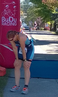 Mary at the finish line bent over after a race.
